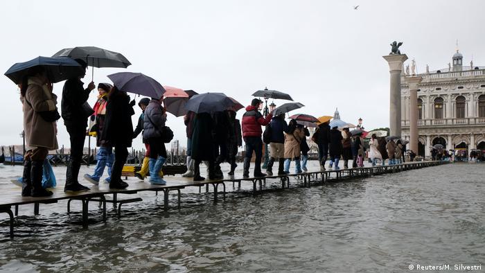 People walk along a catwalk about the Venice floods (Reuters/M. Silvestri)