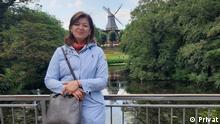 Porträtfoto der Deutschlehrerin Madina aus Tadschikistan mit einer Windmühle im Hintergrund