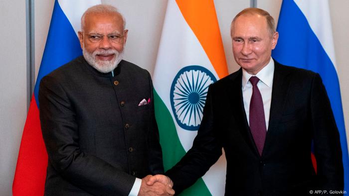 Russian President Vladimir Putin (R) and Indian Prime Minister Narendra Modi shake hands during their meeting on the sidelines of the 11th edition of the BRICS Summit