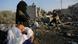 A Palestinian baby is held by a woman near the remains of a house destroyed in an Israeli air strike in the Gaza Strip A Palestinian baby is held by a woman near the remains of a house destroyed in an Israeli air strike in the Gaza Strip