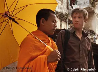 Mönch und junger Mann unter gelbem Schirm - Szene aus SAME SAME BUT DIFFERENT