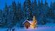 An illuminated Christmas tree in front of a snow-capped chapel An illuminated Christmas tree in front of a snow-capped chapel