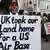 A man holds up a poster reading "The UK took our island home for a US airbas