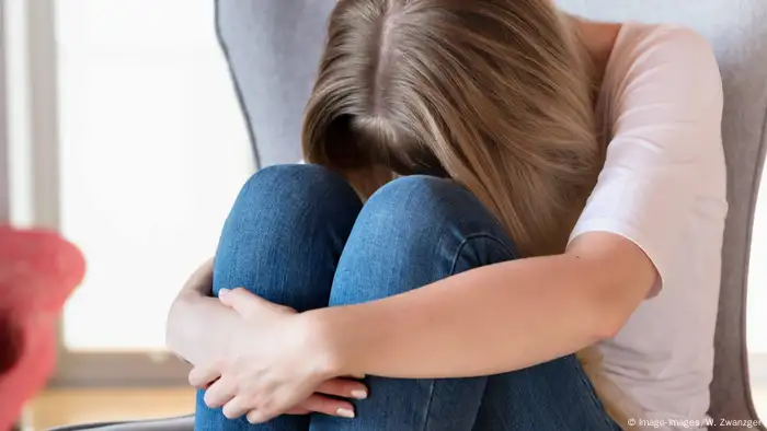 A woman in the fetal position shows signs of grief and depression