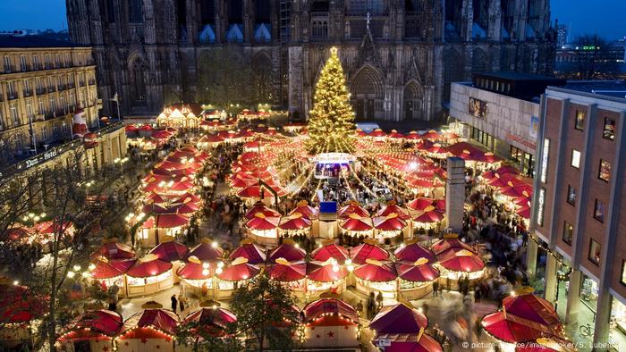 Barracas iluminadas na feira de Natal junto à catedral de Colônia 