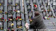 A man places flowers as he takes part in a commemoration ceremony at a monument to the so-called Heavenly Hundred, the anti-government protesters killed during the Ukrainian pro-European Union (EU) mass demonstrations in 2014, to mark the sixth anniversary of the start of the uprising, in Kiev, Ukraine November 21, 2019. REUTERS/Valentyn Ogirenko