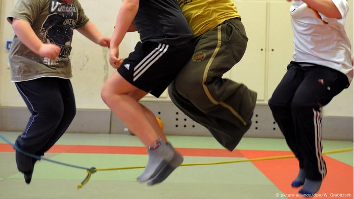 Übergewichtige Kinder hüpfen in einer Sporthalle (picture-alliance/dpa/W. Grubitzsch)