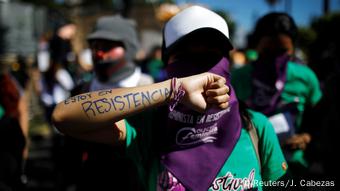 Foto de una mujer que protesta por sus derechos en El Salvador.