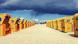 Clouds loom over wicker beach chairs on a beach in northern Germany Clouds loom over wicker beach chairs on a beach in northern Germany