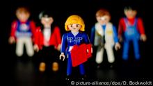 ILLUSTRATION - Eine weibliche Playmobil-Figur mit steht am 05.02.2015 in Hamburg vor mehreren männlichen Figuren. Der Bundesrat befasst sich mit den Gesetzentwürfen zur Frauenquote in Führungspositionen. Foto: Daniel Bockwoldt/dpa | Verwendung weltweit