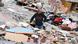 A man stands in the rubble of a collapsed building A man stands in the rubble of a collapsed building