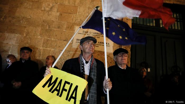 Demonstranten mit Malta- und EU-Flagge und einem Schils Mafia vor dem maltesischen Parlamentsgebäude Demonstranten mit Malta- und EU-Flagge und einem Schils Mafia vor dem maltesischen Parlamentsgebäude