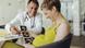 Pregnant woman discussing ultrasound scans with her doctor Pregnant woman discussing ultrasound scans with her doctor