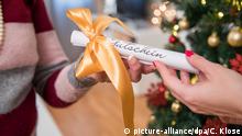 ILLUSTRATION - Eine junge Frau schenkt am 18.08.2017 in einer Wohnung in Hamburg ihrer Mutter einen Gutschein zu Weihnachten (gestellte Szene). Foto: Christin Klose | Verwendung weltweit