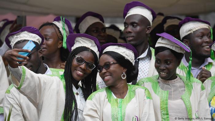 Students in gown and cap celebrate their graduation