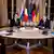 Zelenskiy, Macron, Putin and Merkel sitting around a table