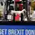 Britain's Prime Minister and Conservative leader Boris Johnson drives a Union flag-themed JCB, with the words "Get Brexit Done" inside the digger bucket, through a fake wall 