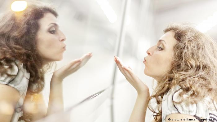 Женщина смотрит в зеркало