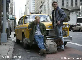 Zwei junge Rucksacktouristen vor gelbem New Yorker Taxi in Straßenschlucht (Verleih Sony)