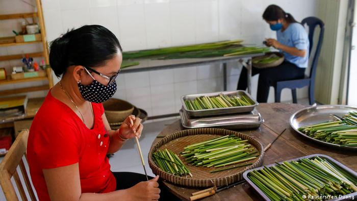 Workers make straws from grass (Reuters/Yen Duong)