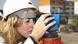 A female engineer wearing a hard hat and taking measurements on a construction site A female engineer wearing a hard hat and taking measurements on a construction site