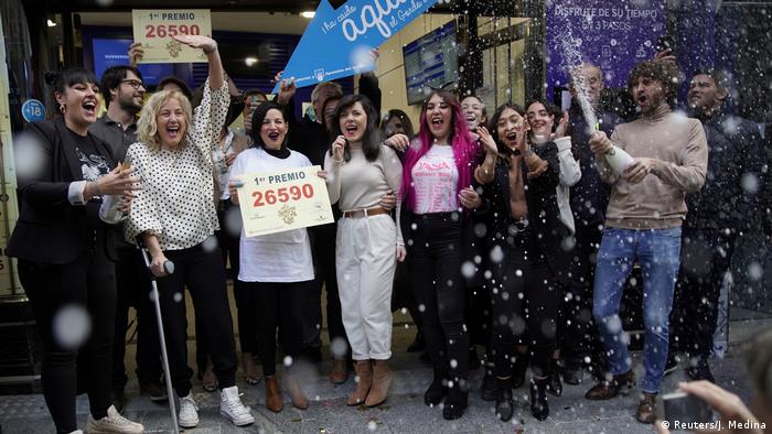 Owners and employees of the shop Dona Manolita celebrate selling the winning ticket of the biggest prize in Spain's Christmas lottery El Gordo 