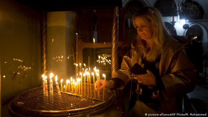 Westjordanland Bethlehem | Besucher zündet Kerze in der Church of Nativity Geburtskirche