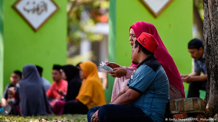 Groups of people sit and pray at a cemetary in Banda Aceh (Getty Images/AFP/C. Mahyuddin)