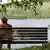 Rentnerin auf Holzbank am See