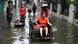 A woman is pushed down a flooded street in Jakarta, Indonesia. A woman is pushed down a flooded street in Jakarta, Indonesia.
