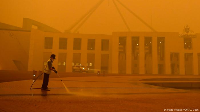The man in front of the Australian Parliament in Canberra failed to cover the flames with his high-pressure cleaner.