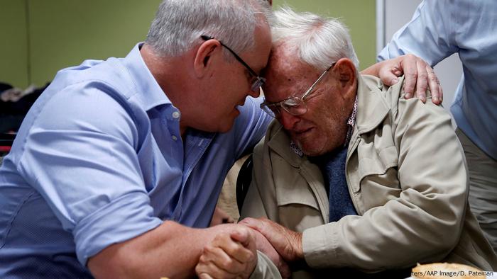 Scott Morrison comforts an old man.