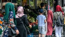Strassenszene Sonnenallee, Berlin-Neukölln. Bei Anwohnern, aber auch über Berlin hinaus, heisst die Strasse auch ?Arabische Straße?. Viele arabisch- syrische Migranten und Flüchtlinge haben sich hier etabliert in einer quasi Parallelwelt als Gemüsehändler, Frisör, Bäcker, mit Läden für arabische Brautmoden oder Reisebüro. Die Kehrseite: die Strasse, dass Kiez gilt auch als sozialer Brennpunkt und wird immer wieder mit arabischen Clans in Verbindung gebracht.Foto:Winfried Rothermel | Verwendung weltweit