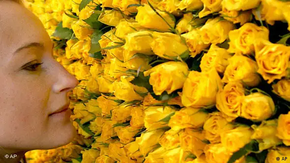 Frau riecht an gelben Rosen (Foto: AP)