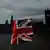 Bandeiras da Inglaterra, com o prédio do Parlamento britânico ao fundo, em Londres