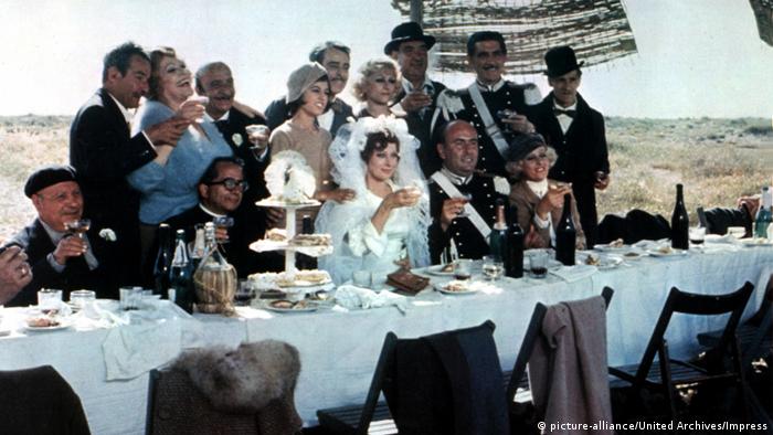 Photo from the film Amarcord, newlyweds and guests at a long table outside