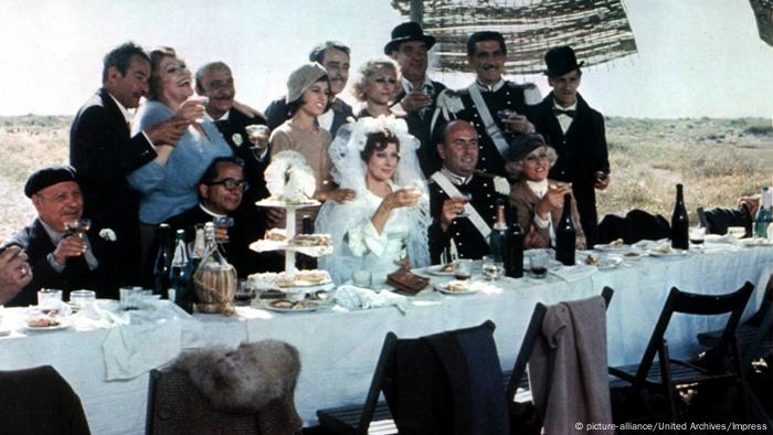 Film still Amarcord, bride and groom and guests at a long table outdoors