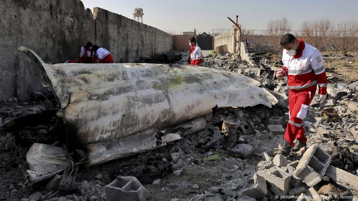 Pieces of the wrecked plane with rescue workers