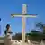  Residents stand next to a cross during a memorial service honoring the victims of the 2010 earthquake, at Titanyen, a mass burial site north of Port-au-Prince, Haiti
