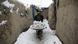 A refugee carries snow after a snowstorm at a camp in Kabul. A refugee carries snow after a snowstorm at a camp in Kabul.