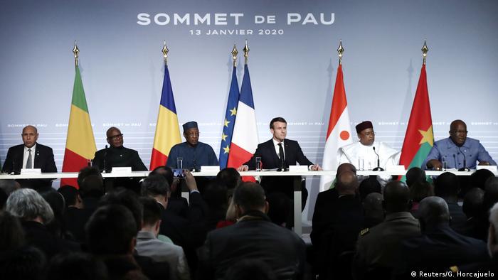 Leaders of G5 Sahel summit sit at a table on stage