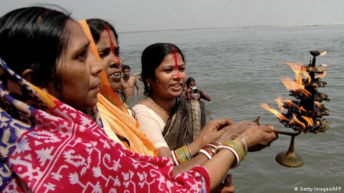 Indian Hindu devotees hold a lamp as they pray in celebration of the 'Ganga Dussehra' Festival on the banks of the River Ganges at Patna