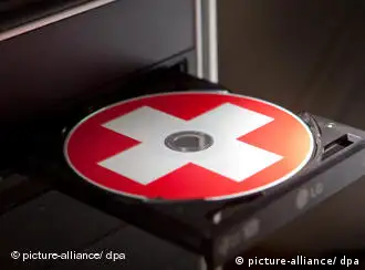 A CD with a Swiss flag rests in the CD drive tray of a computer in this photo-illustration