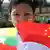 A child in Myanmar holds the Chinese and Myanmar flag