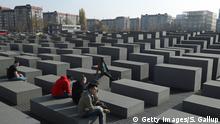 BERLIN, GERMANY - NOVEMBER 07: Visitors sit on stellae at the Monument to the Murdered Jews of Europe, also called the Holocaust Memorial, prior to the 80th anniversary of the Kristallnacht pogroms on November 7, 2018 in Berlin, Germany. During November 7-13, 1938, Nazi supporters attacked over 1,400 synagogues as well as Jewish businesses and individuals that led to the deaths of over 400 people in a violent outburst of anti-semitism that preceded the horrors of the Holocaust. Germany will officially commemorate the 80th anniversary on November 9. (Photo by Sean Gallup/Getty Images)