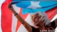 January 20, 2020***
A woman carries a flag during a protest against Puerto Rico Governor Wanda Vazquez and the government in San Juan, Puerto Rico on January 20, 2020, after a warehouse filled with unused emergency supplies dating from Hurricane Maria in 2017 was found earlier in the week. (Photo by Ricardo ARDUENGO / AFP)