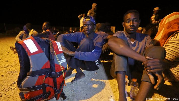  Rescued African migrants sit on Libyan coast after being rescued from the Mediterranean Sea.