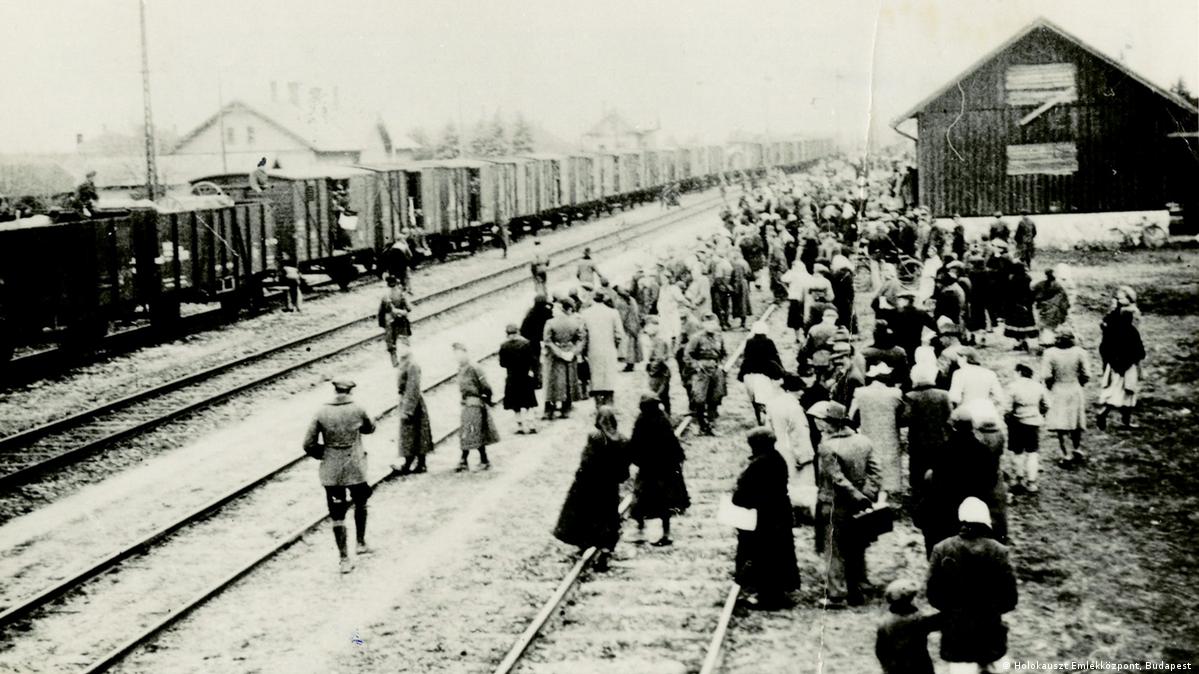 Foto histórica mostra pessoas nos trilhos ao lado de um trem