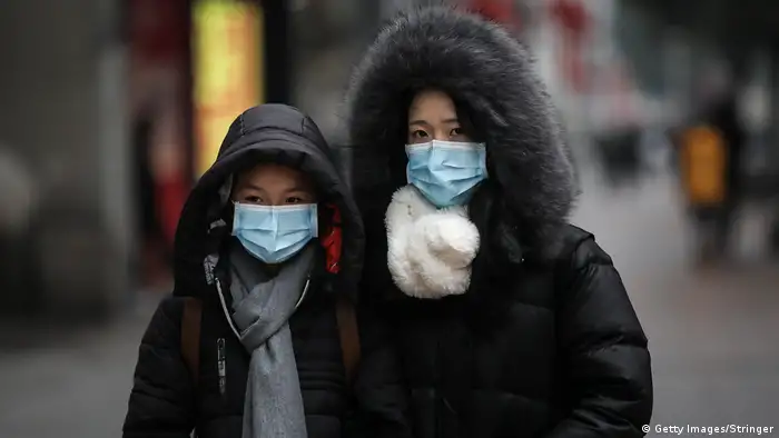 A family wears masks while walking in the street on January 22, 2020 in Wuhan, Hubei province, China. (Getty Images/Stringer)