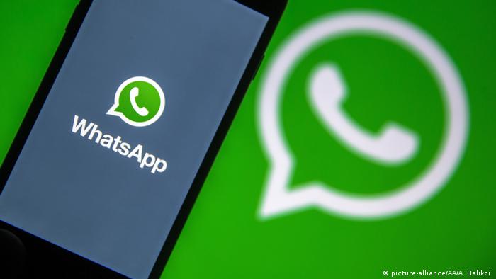 A symbolic photo of a phone screen displaying a WhatsApp logo